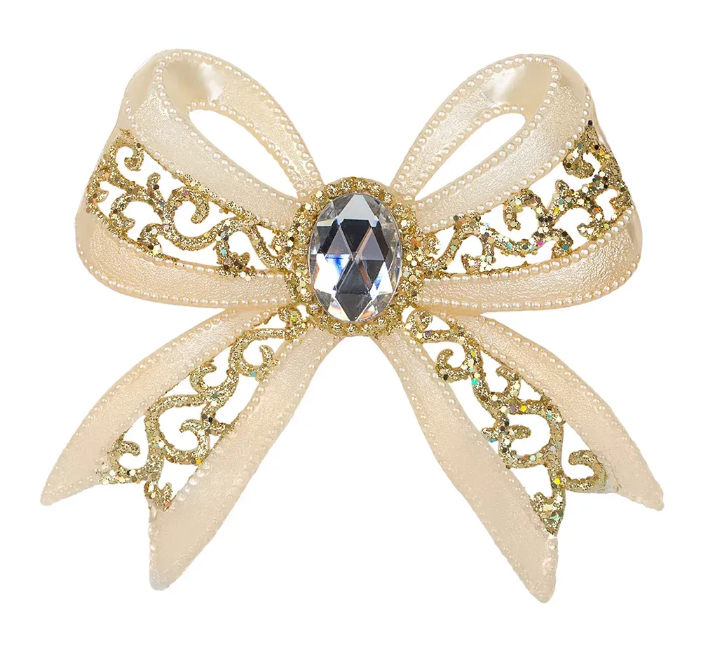 Closeup of champagne colored bow brooch against white background