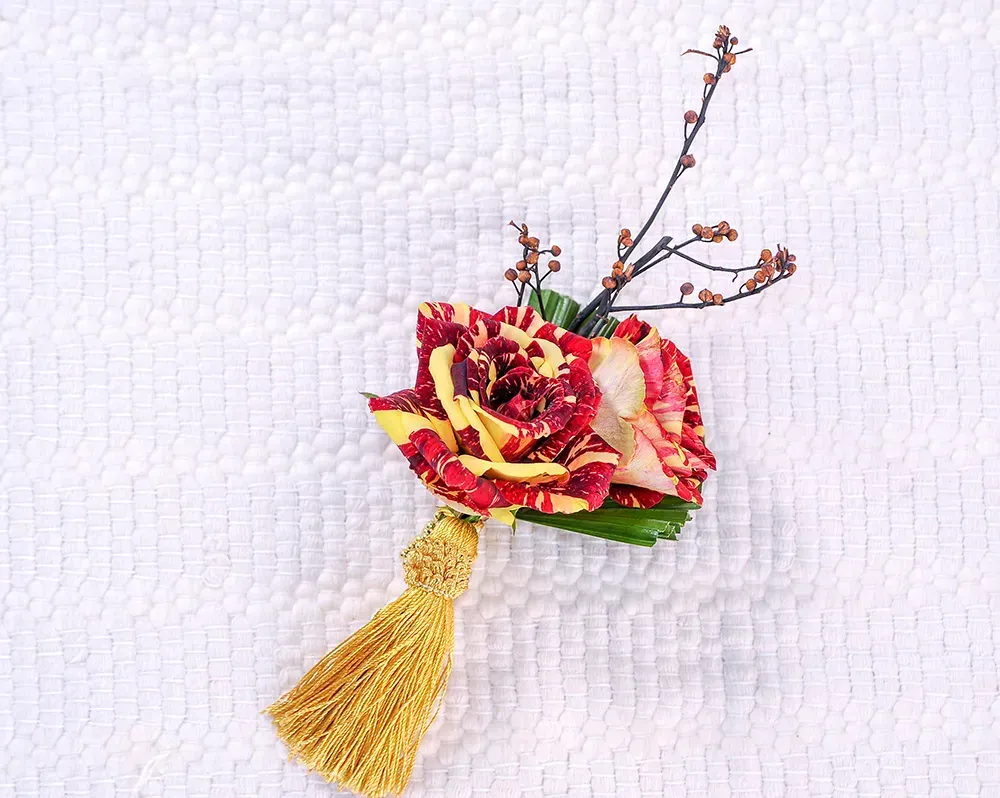 Closeup of flower and yellow tassel brooch