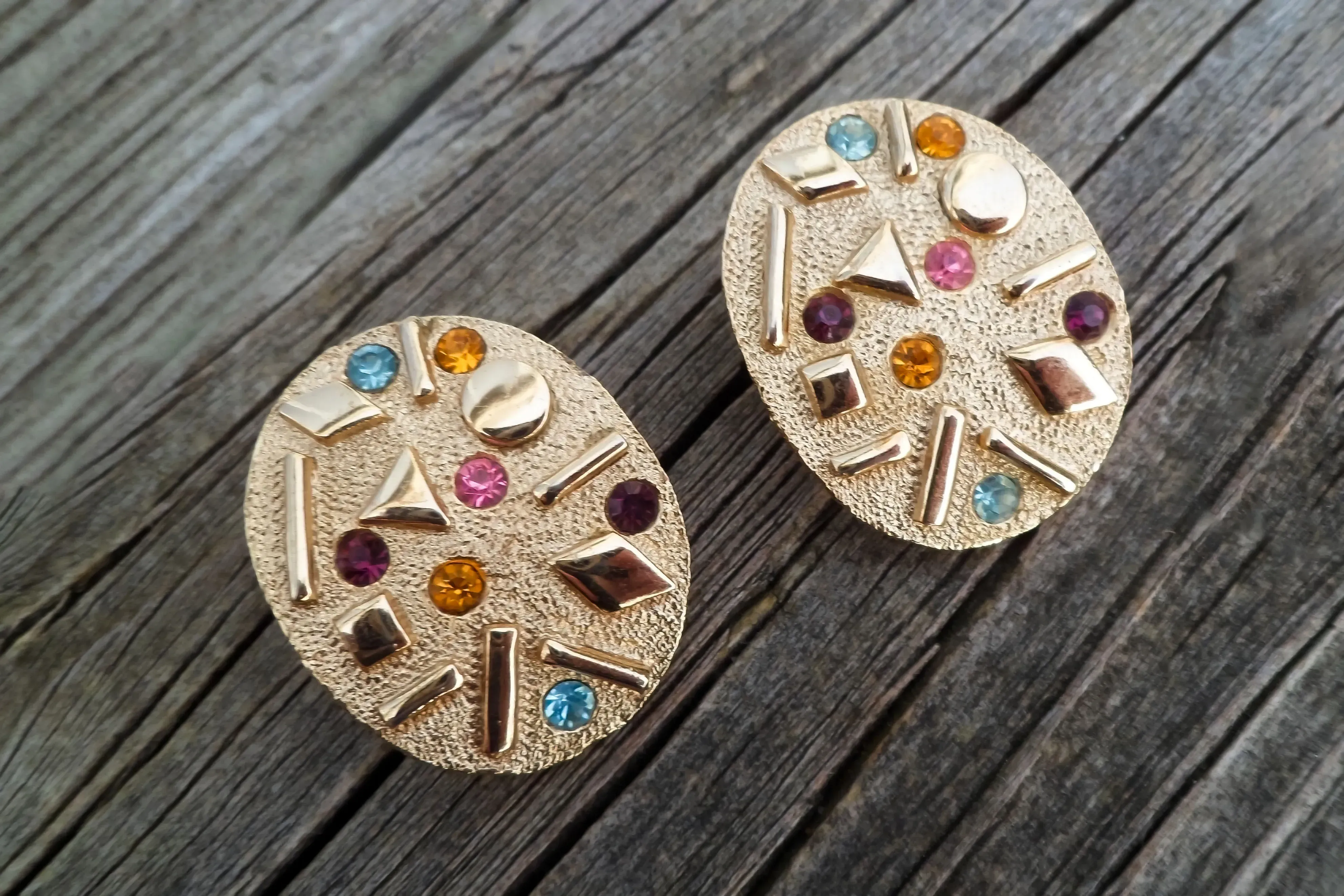 1960s clip-on earrings featuring colored crystals and geometric designs.