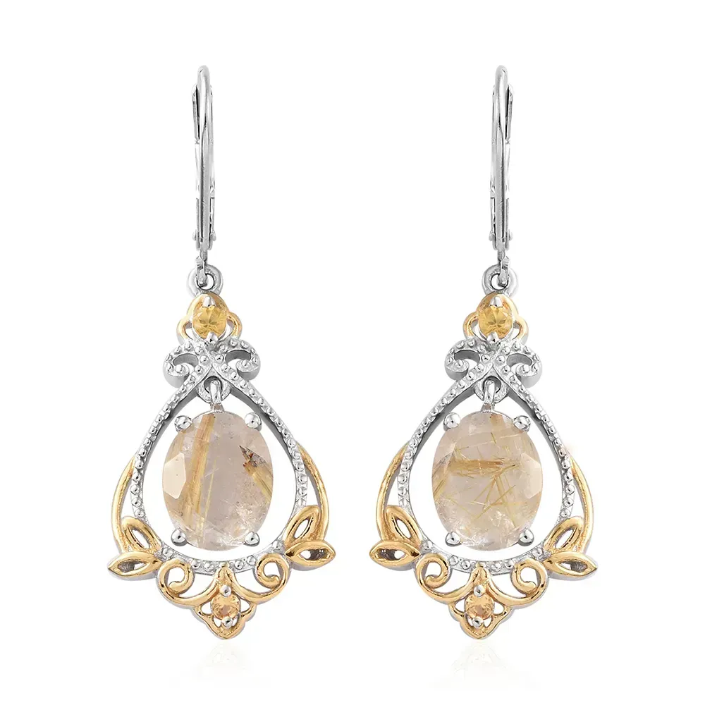 Closeup of yellow gold dangle earrings against white background