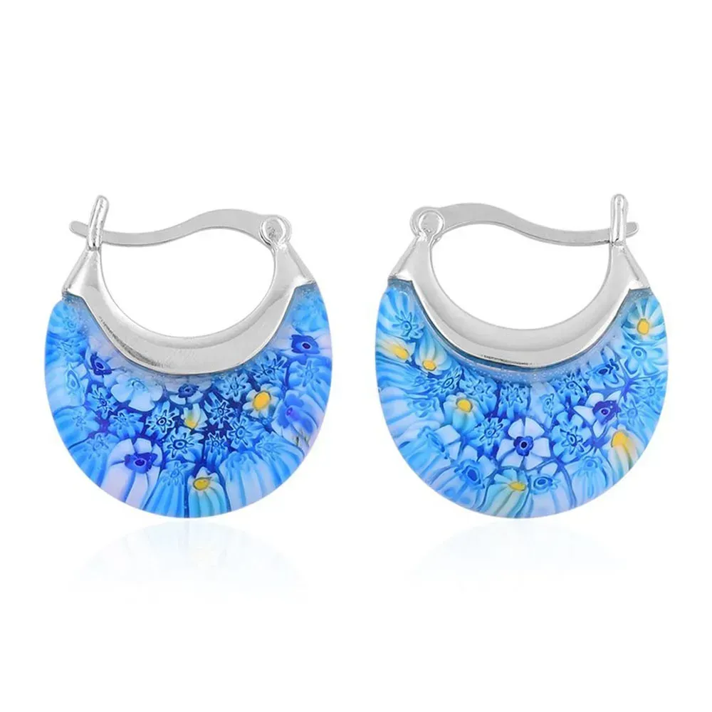 Closeup of blue earrings against white background