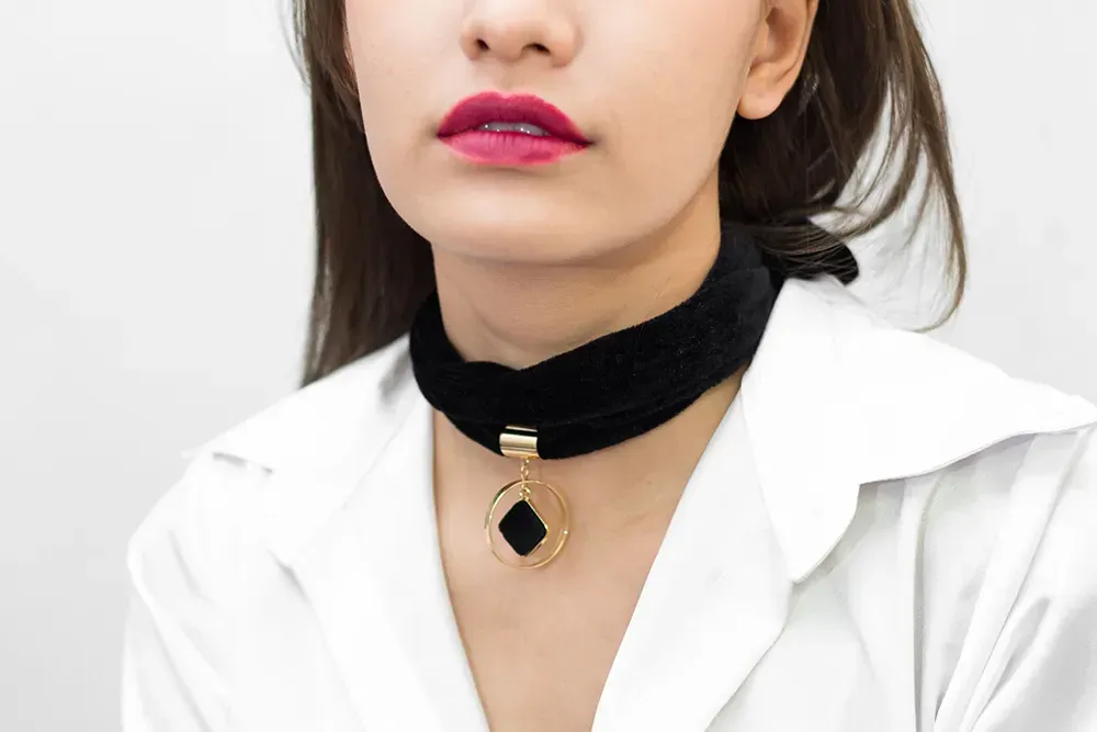 Closeup of woman wearing black bib necklace