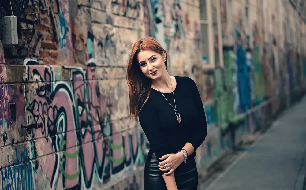 Woman wearing black tee with long pendant necklace