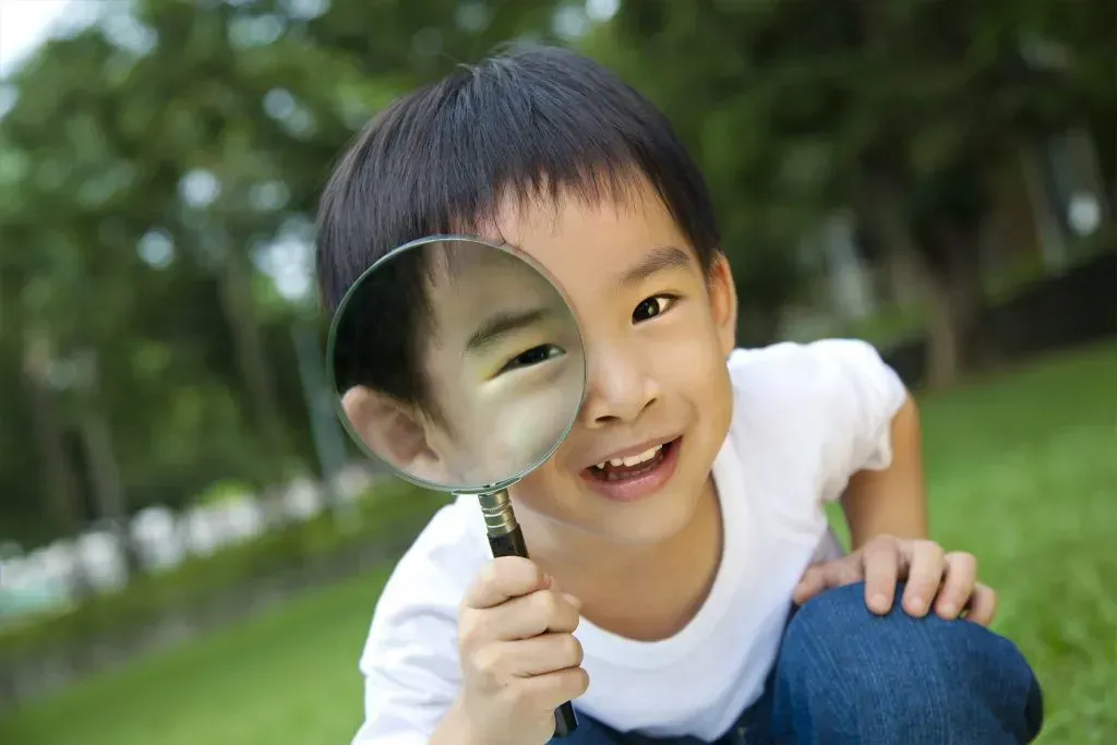 Happy kid with magnifying glass.