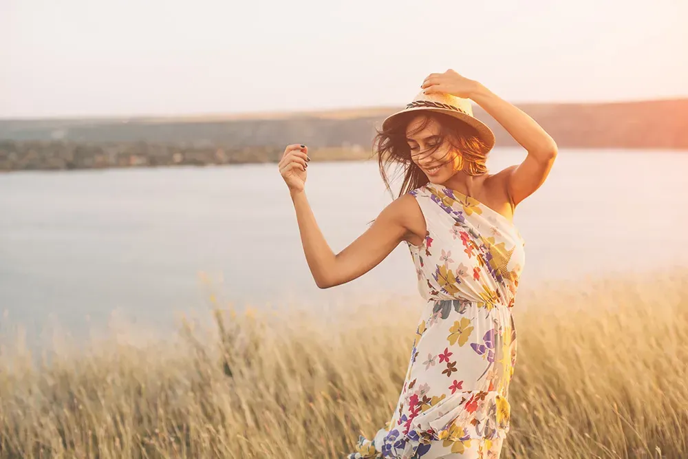 Woman wearing floral flowy dress by the lake