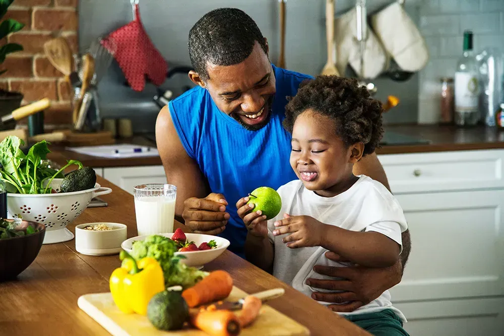 A child and his father preparing a healthy meal.