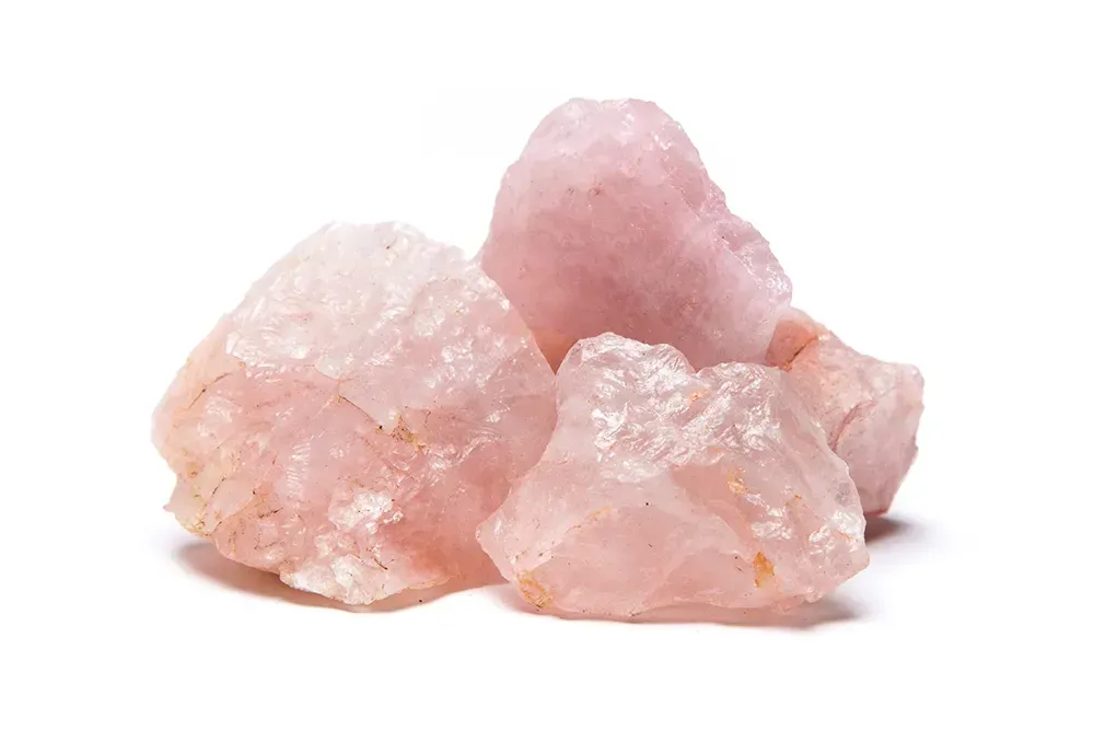 Raw rose quartz against a white background.