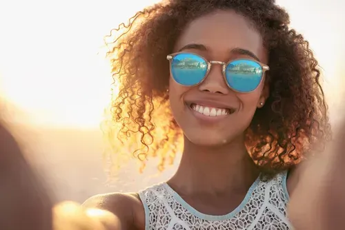 A woman smiling in sunglasses.