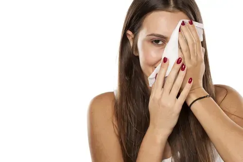 Woman cleaning her face with a baby wipe.
