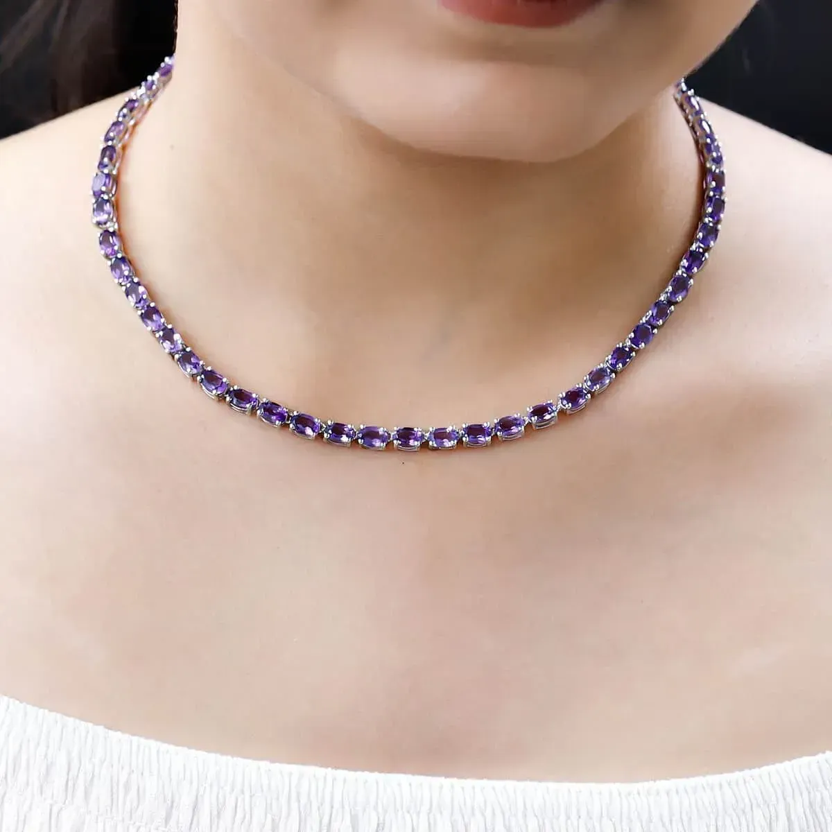 Woman modeling Lusaka Amethyst Necklace Sterling Silver, Silver Tennis, Open Box Clasp.