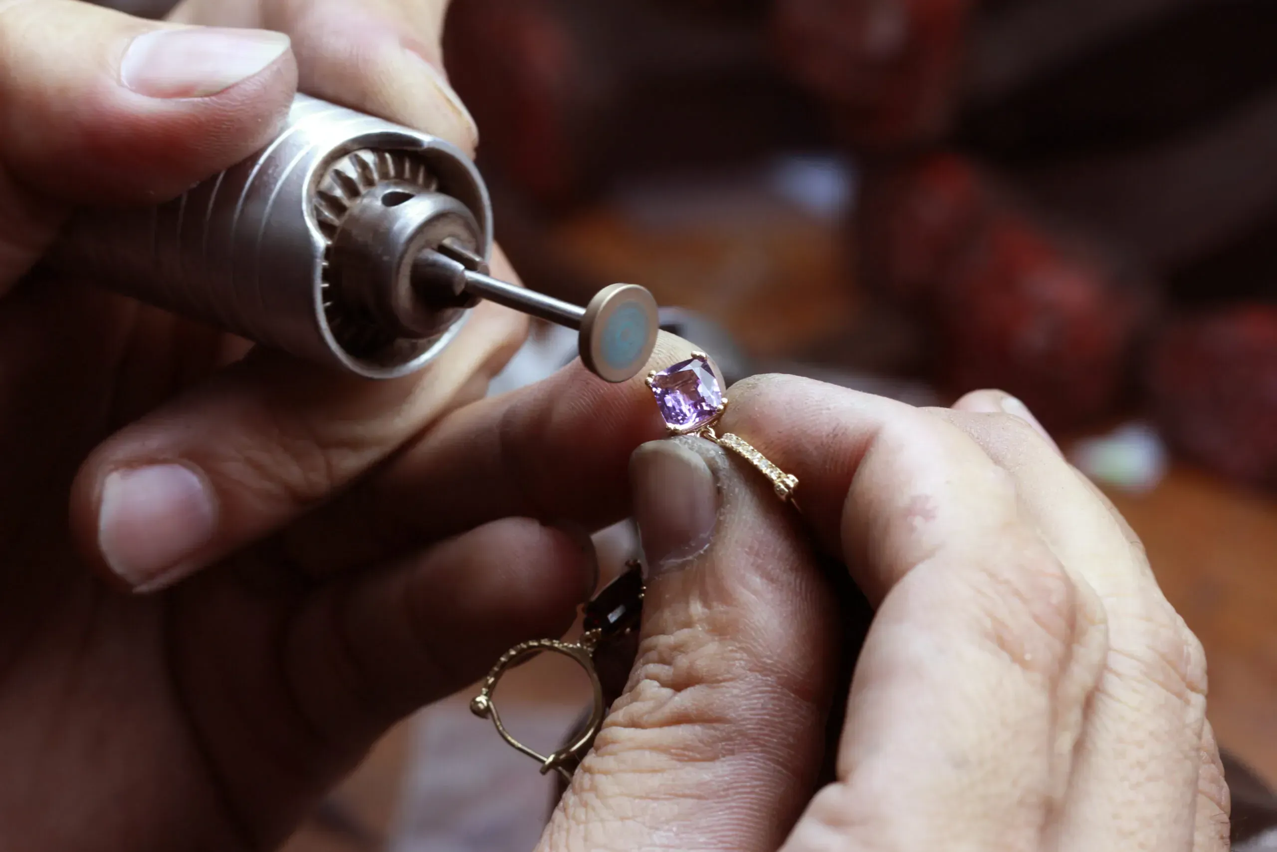 Closeup of jeweler working on amethyst jewelry. 