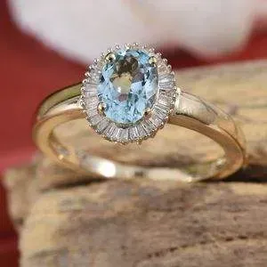 Aquamarine halo ring resting in fancy wooden display setting.