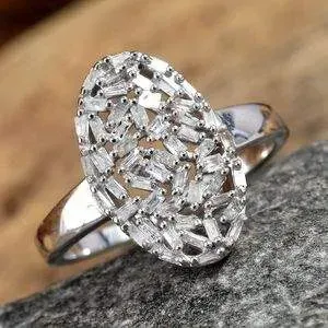 Oval diamond cluster ring resting on granite stone. 