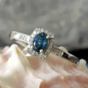 Montana sapphire rest atop a pink shell. 