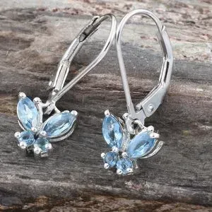 Aquamarine butterfly earrings on wood background.