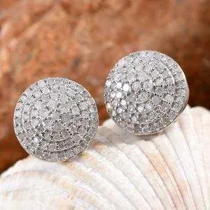 Diamond cluster earrings resting on shell. 
