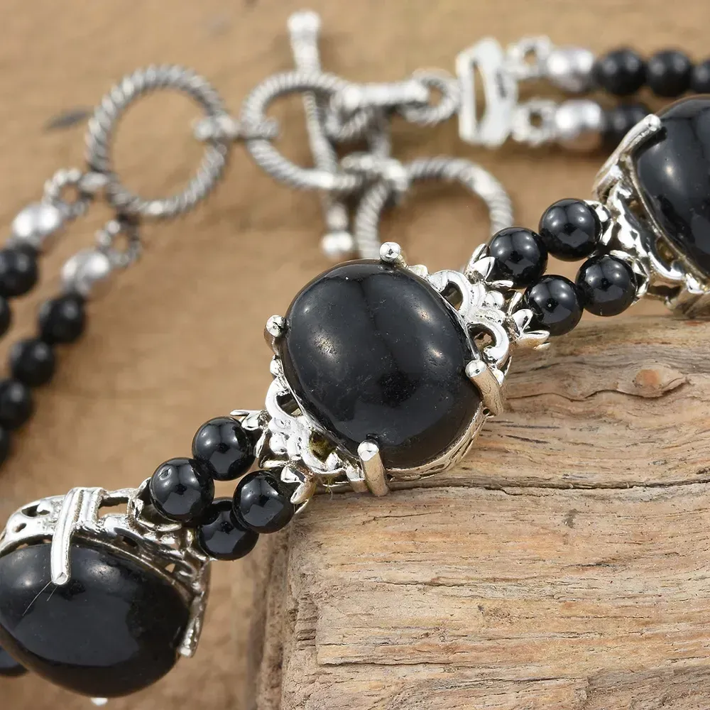 Black jade bracelet against wooden platform