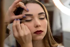 Woman having black eyeliner applied.