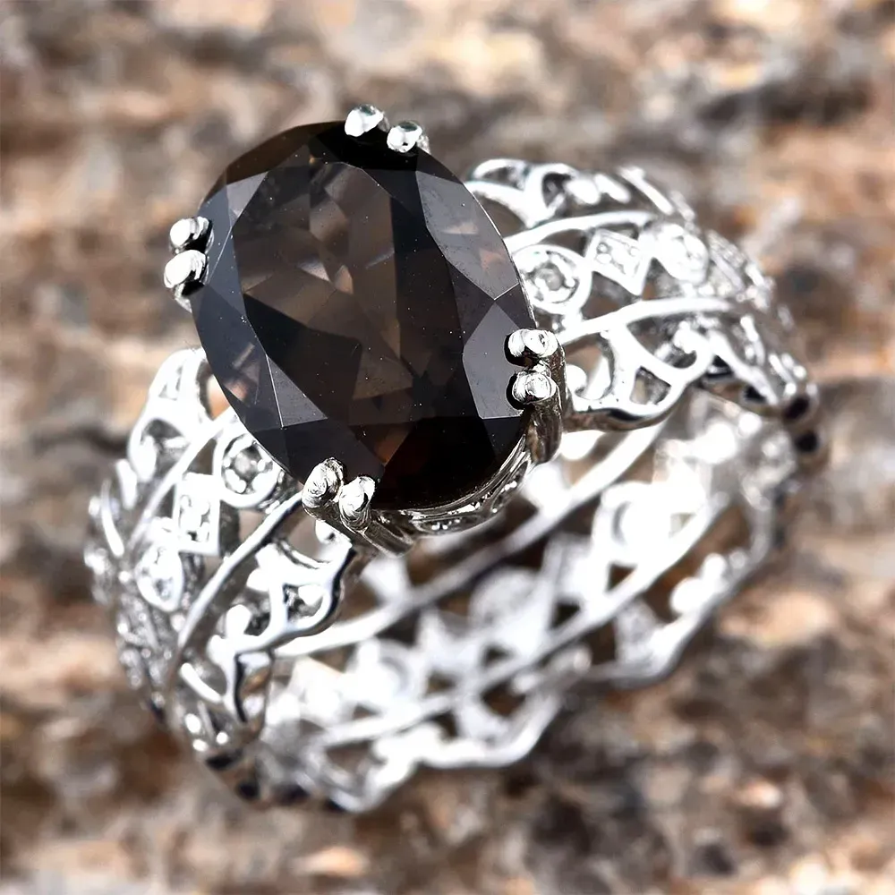 Smoky quartz ring against rocky background. 