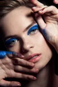 Woman with dramatic blue eye makeup.