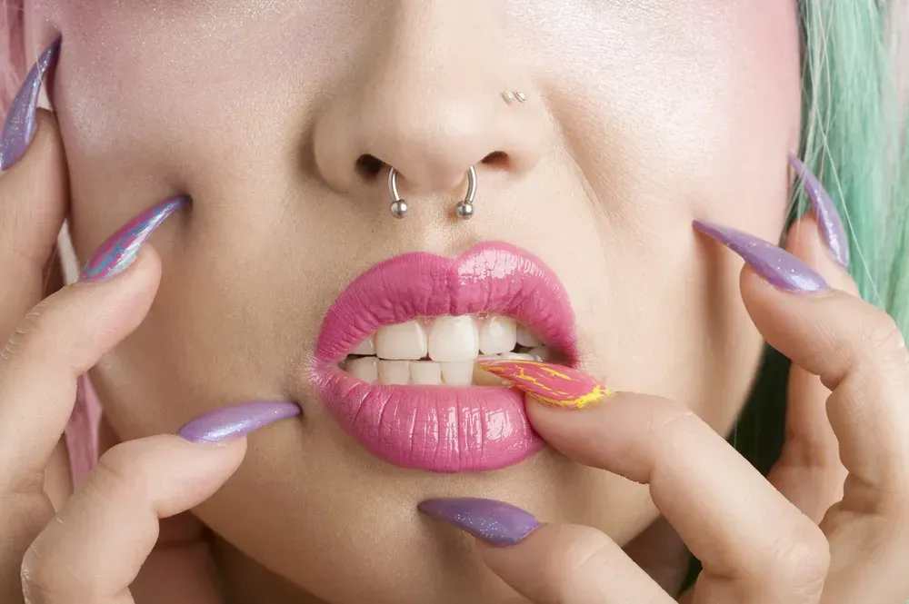 Close-up of woman's mouth and fingers.
