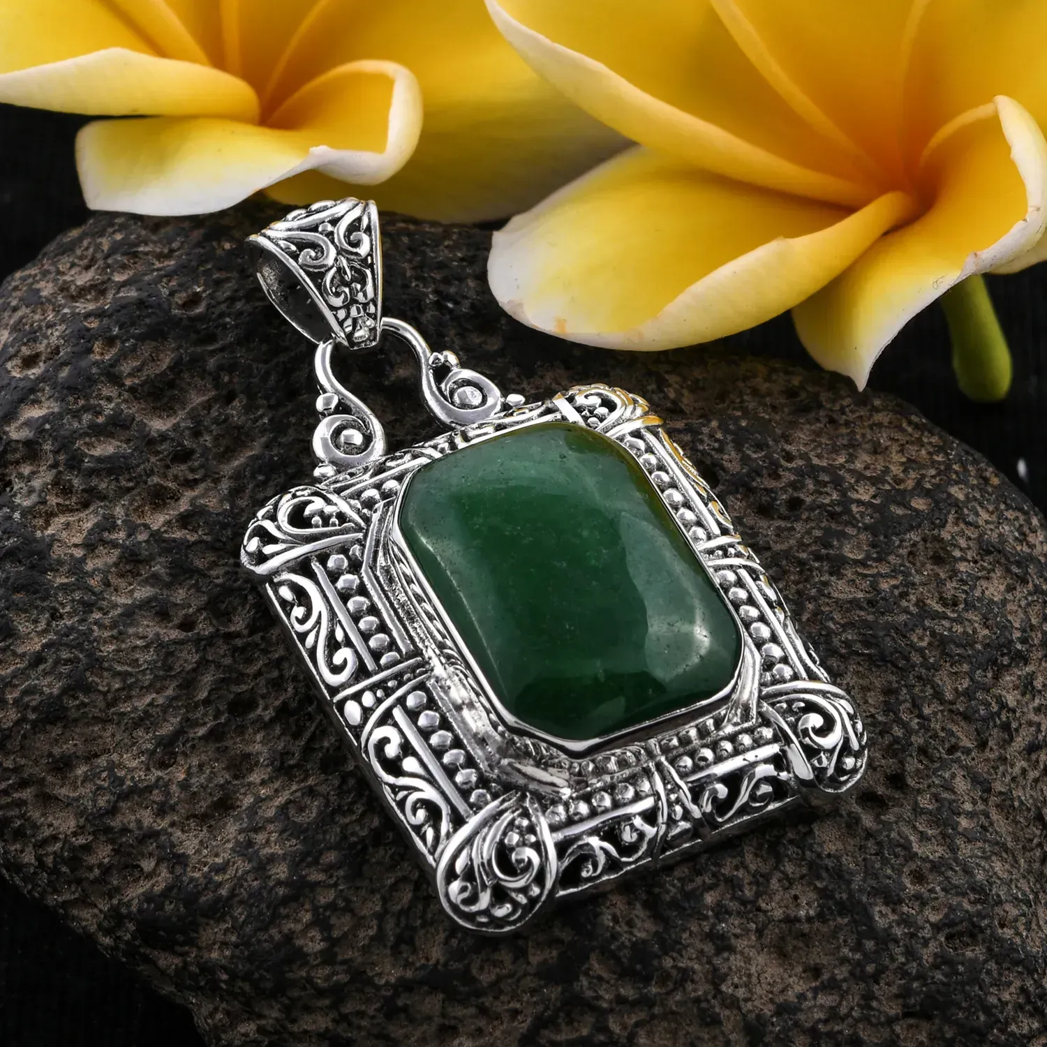 Bali crafted jade pendant on gray stone. 