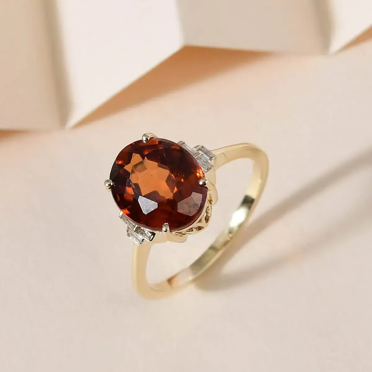 Luxoro 10K Yellow Gold Premium Sri Lankan Honey Garnet and Diamond January Birthstone Ring on neutral cream background.