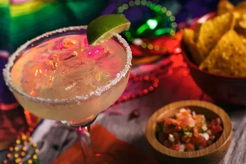 Ice cold margarita on a table full of Mexican-American food. 