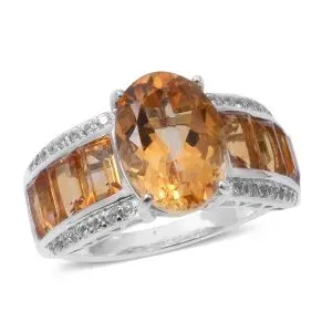 Orange citrine ring against white background. 