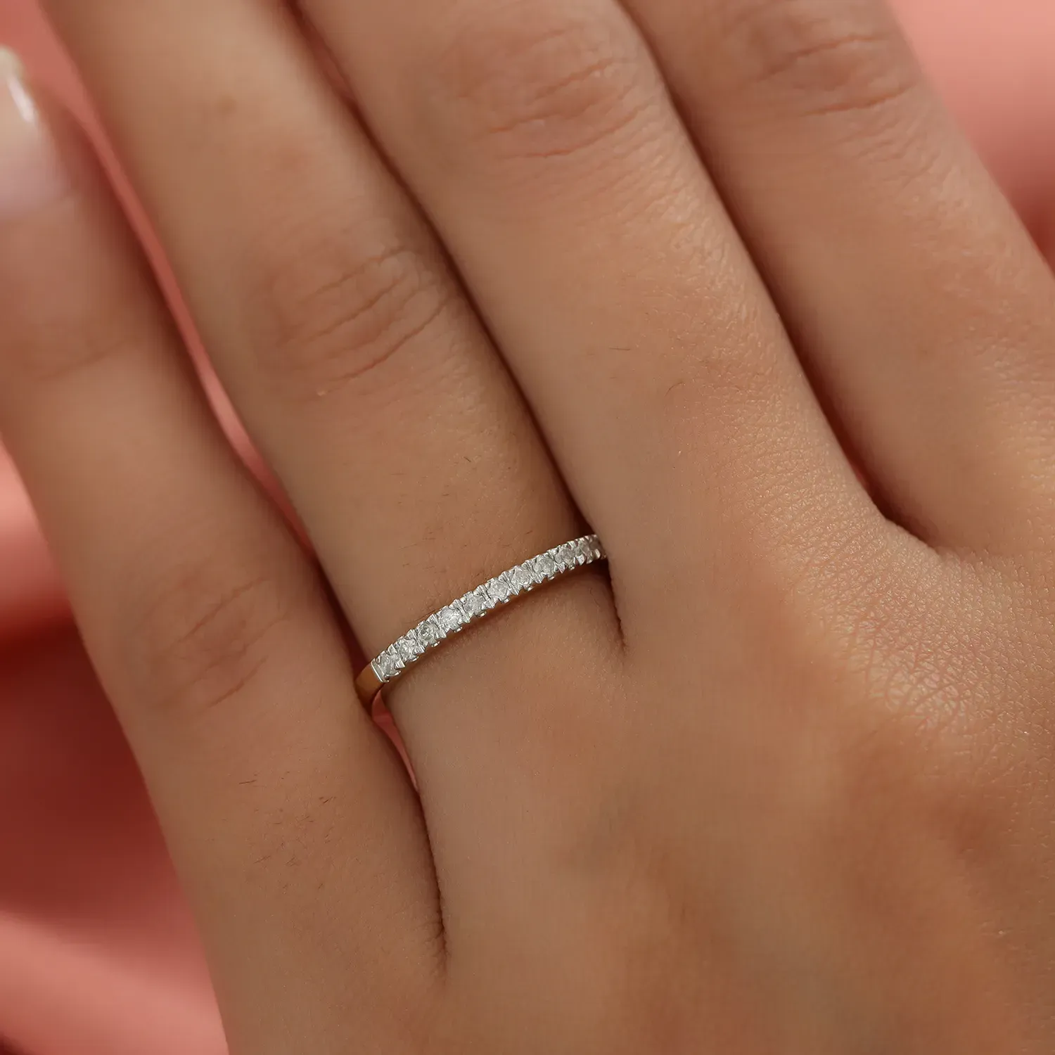Closeup of hand displaying diamond wedding band on finger.