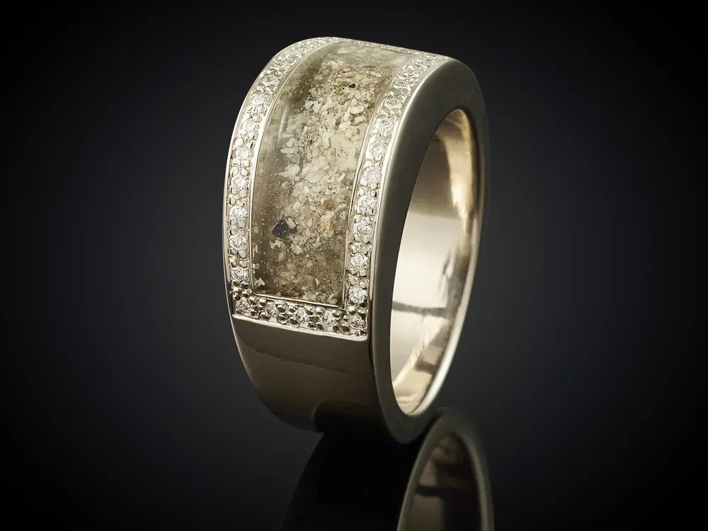 Golden ring with ashes isolated on black.