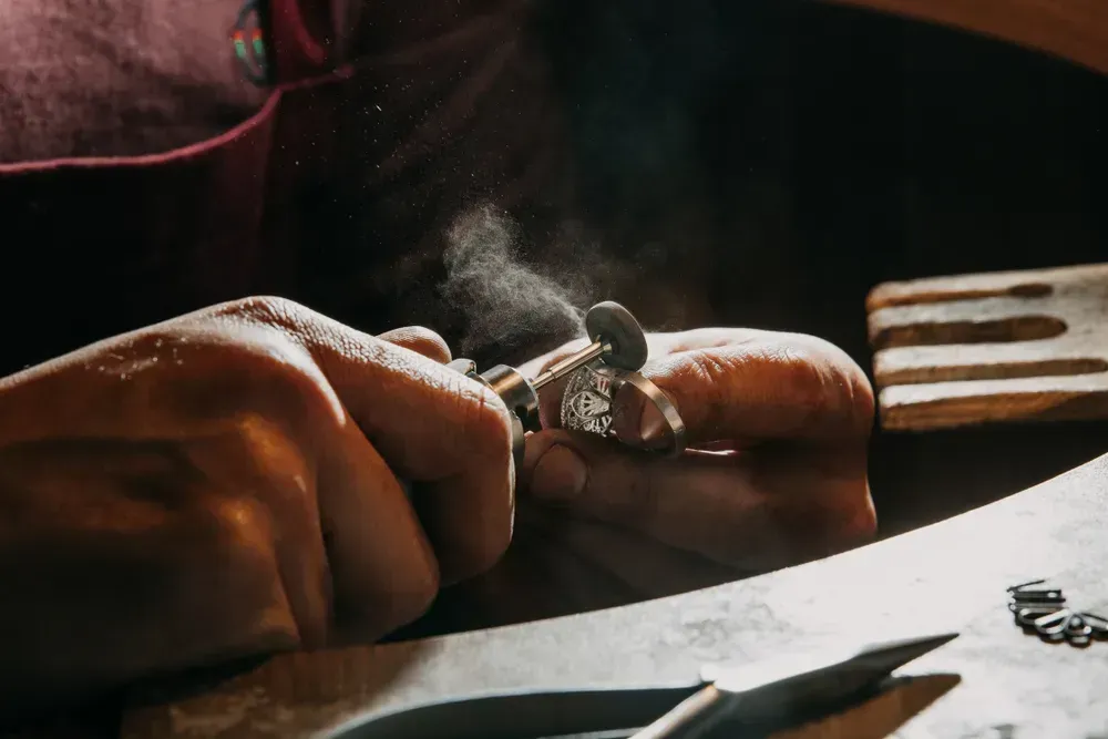 Close-up of a hand of a goldsmith who builds a precious jewel with valuable diamonds. To make the jewel it takes: precision, craftsmanship and patience.