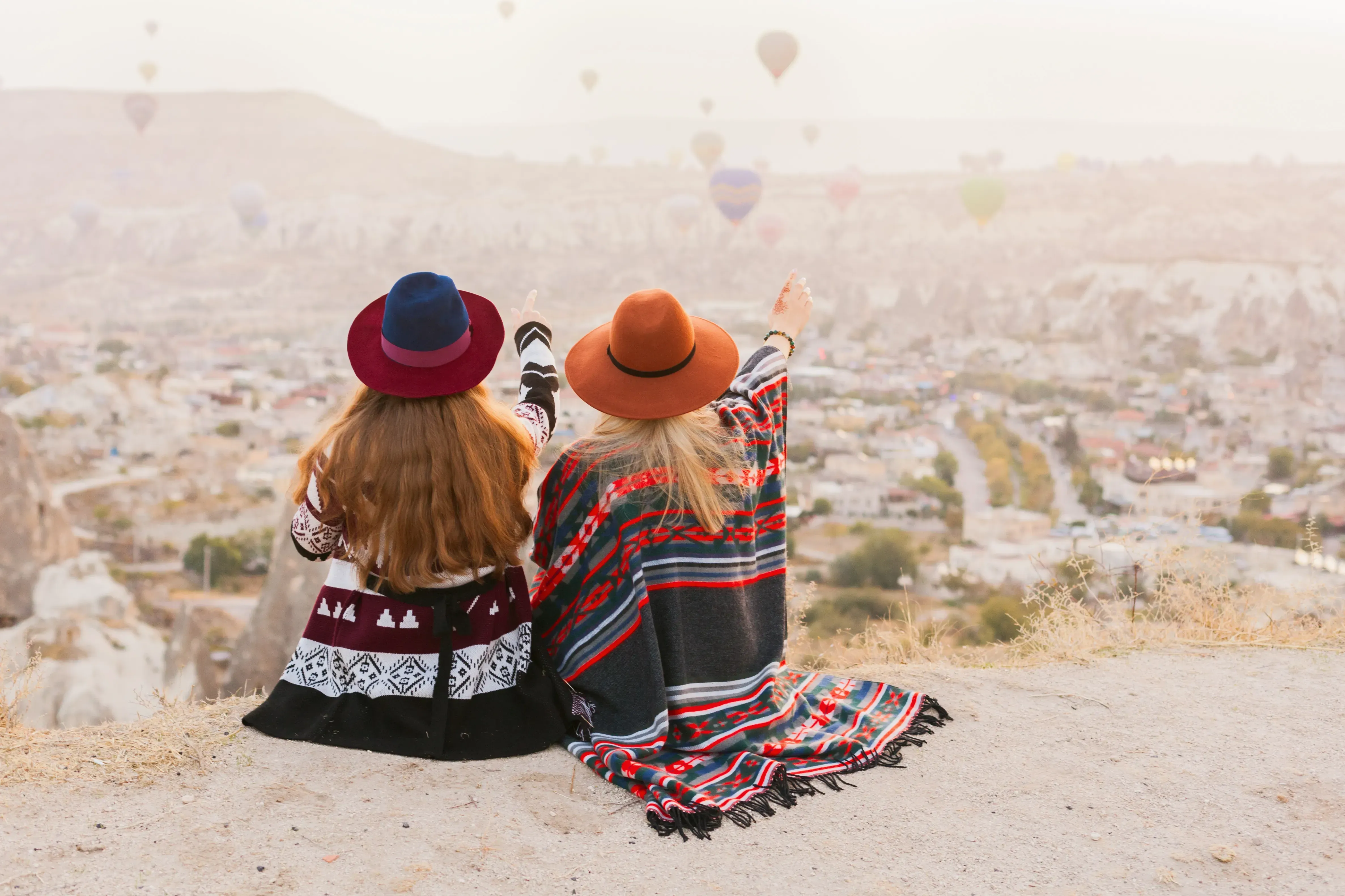Women wearing Southwestern-inspired clothing watching hot air balloons. 