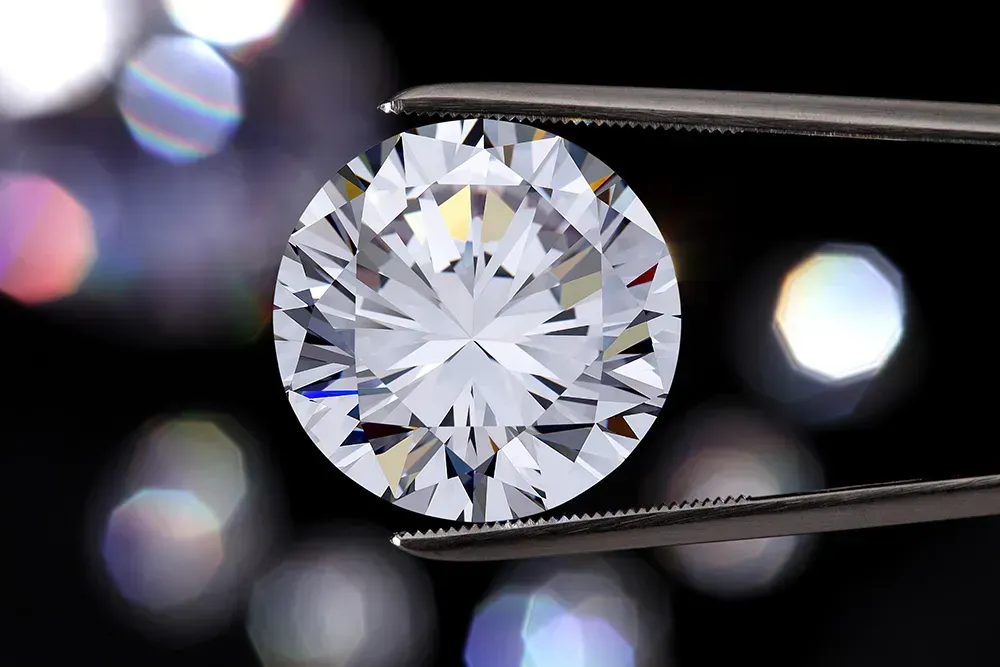 Closeup of diamond held with tweezers.