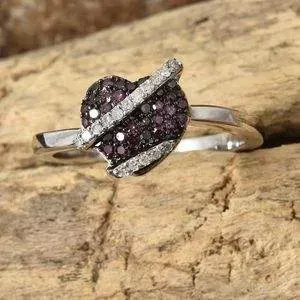 Heart-shaped purple diamond ring on wood base.