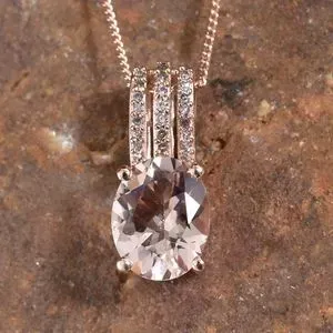 Morganite and pink diamond pendant resting on stone.
