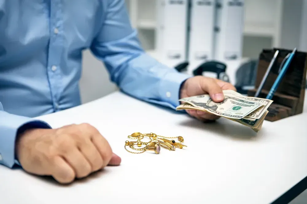 Person selling gold jewelry for cash.