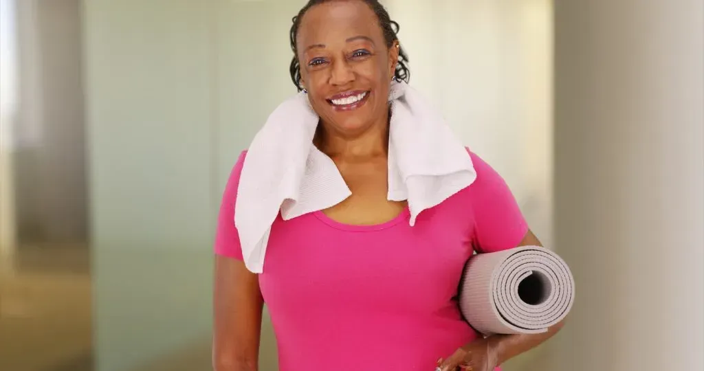 Elderly Black woman smiling after a workout.
