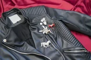 Leather jacket decorated with pins and brooches.