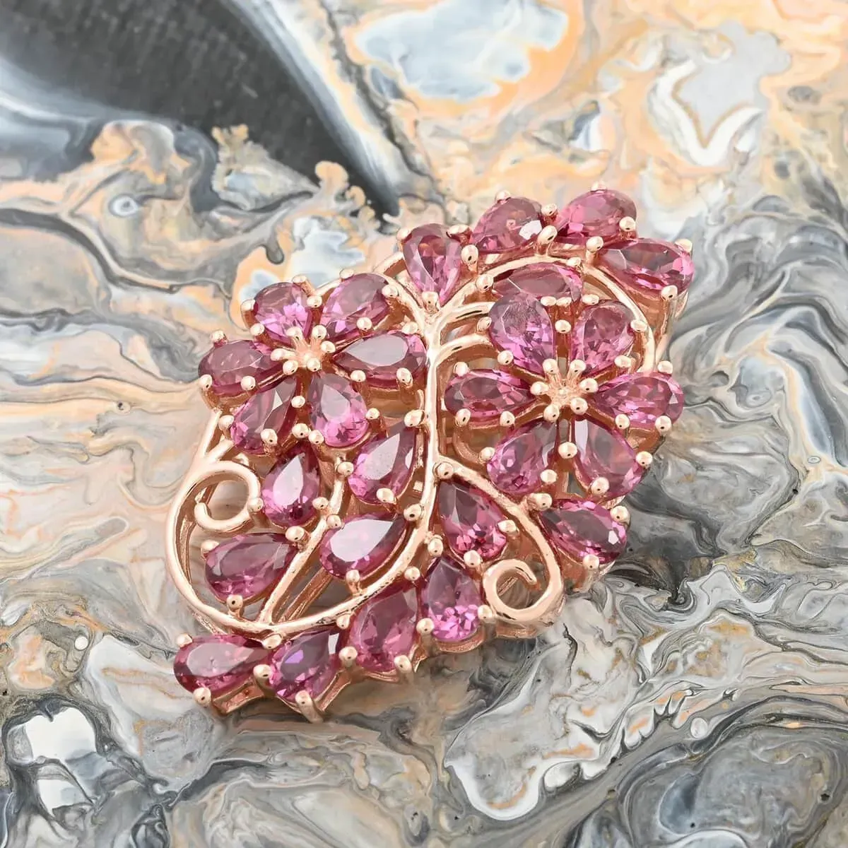 Orissa Rhodolite Garnet Floral Pendant in Vermeil Rose Gold Over Sterling Silver 7.00 ctw against swirled marble background. 