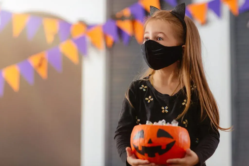 Girl wearing mask that matches with her costume.