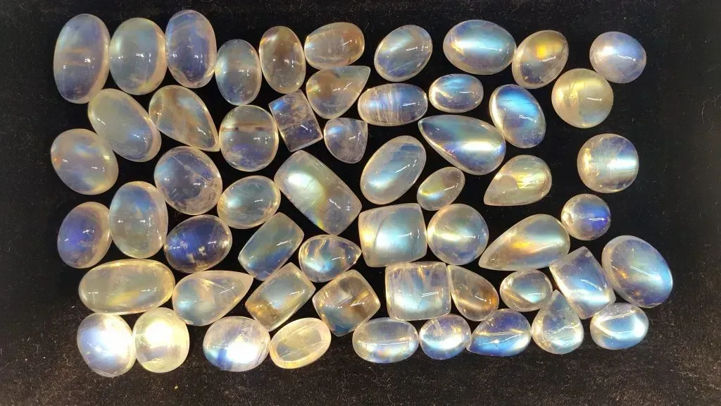Finished moonstone cabochons on black background.