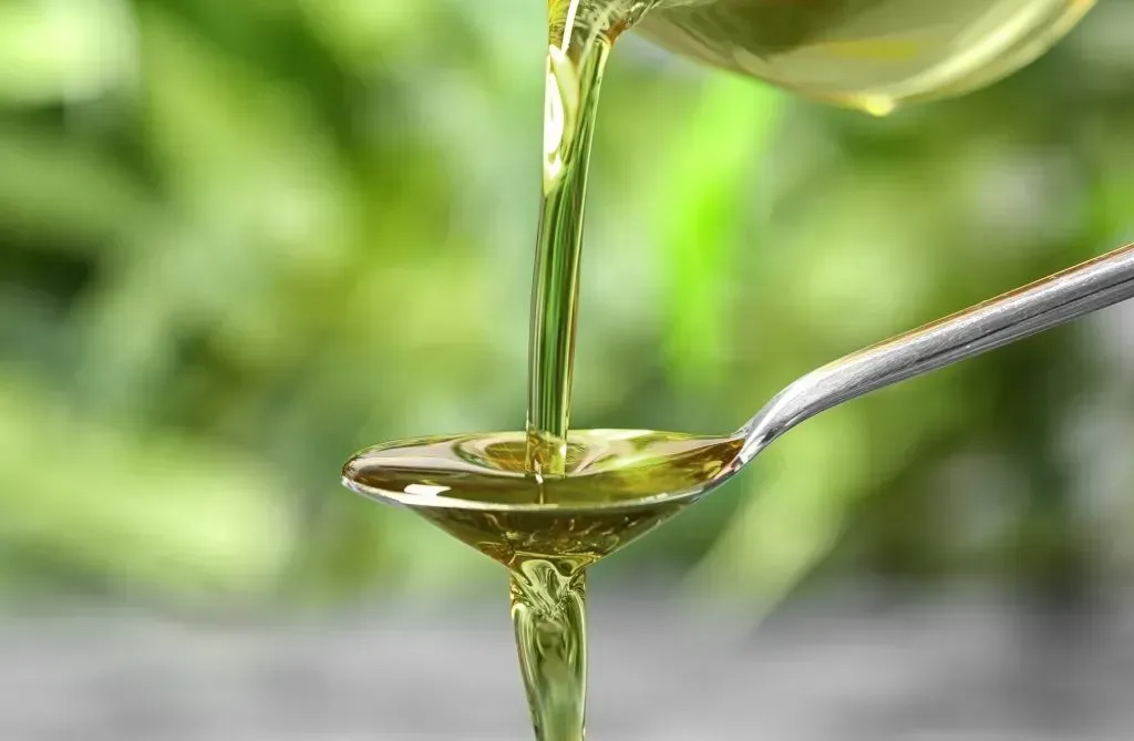 Hemp oil pouring over a spoon.