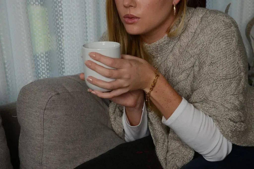 Blonde woman holding cup on coffee.