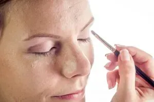 Woman applying eyeshadow primer