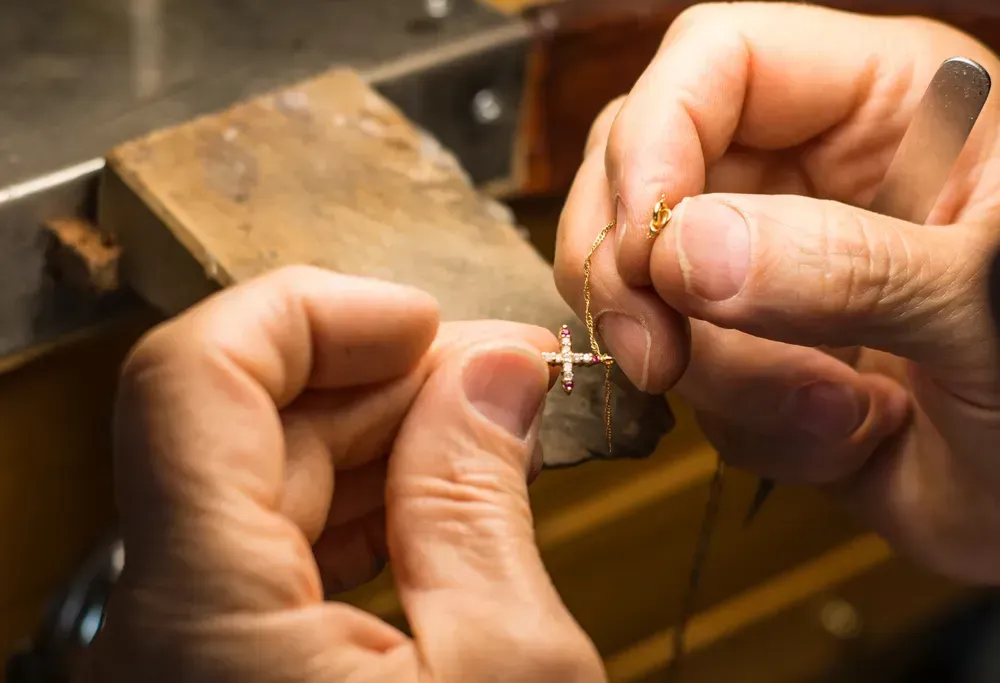 Hands of a craftsman jeweler working on jewelry. 