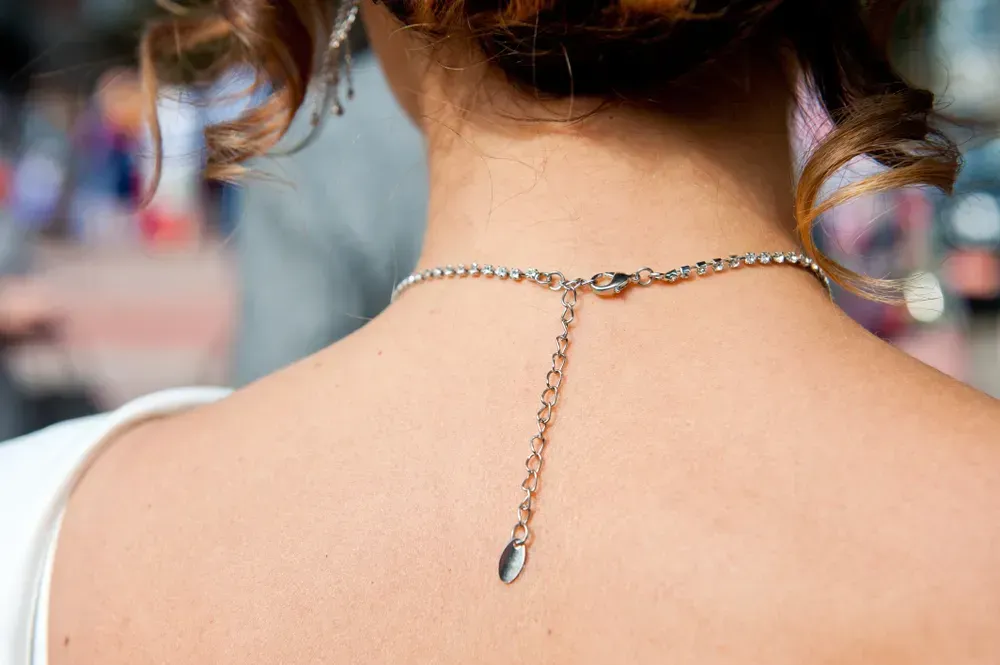 Clasp chain jewelry necklace on the neck of a young girl.