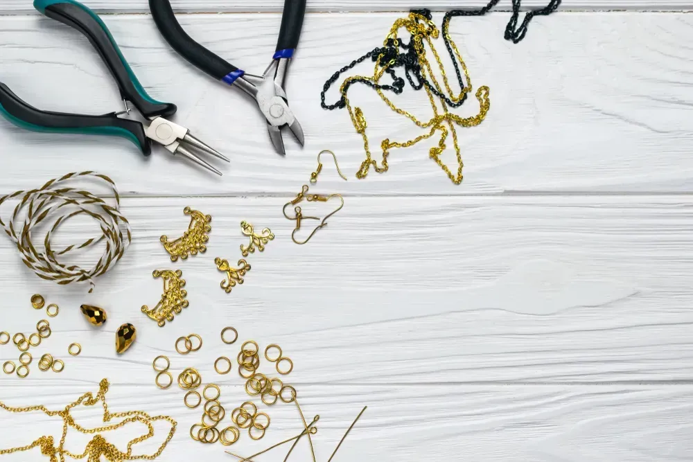 Jewelry findings handmade craft composition with pliers beads embellishments.