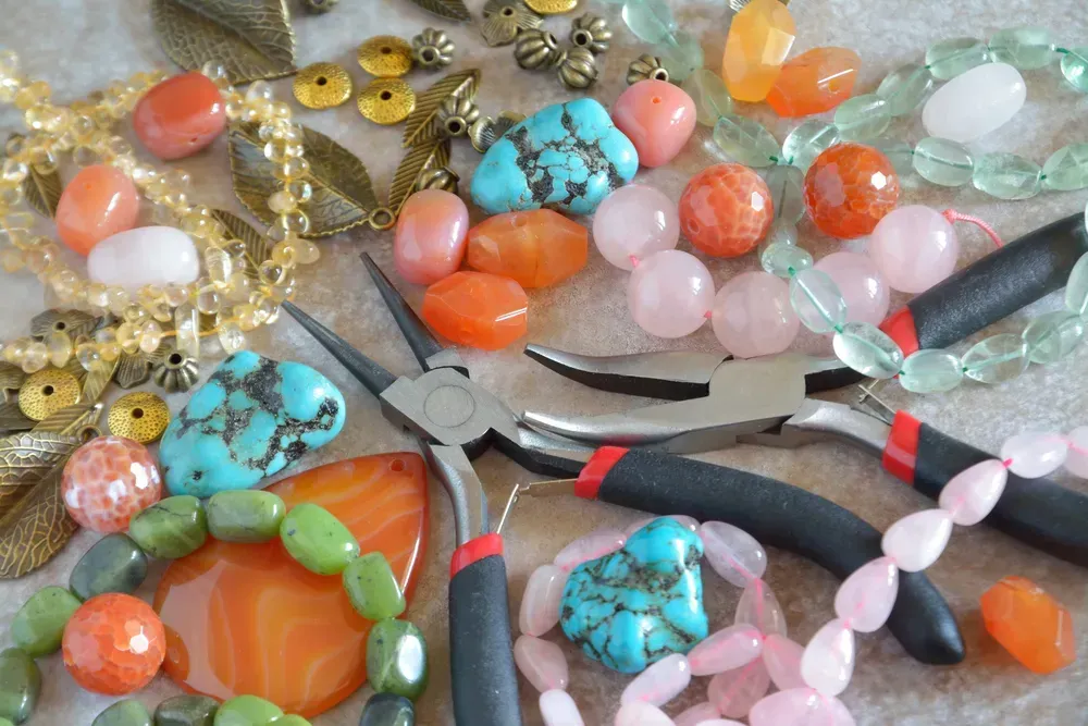 Tools for jewelry making, colorful stone beads and metal findings.
