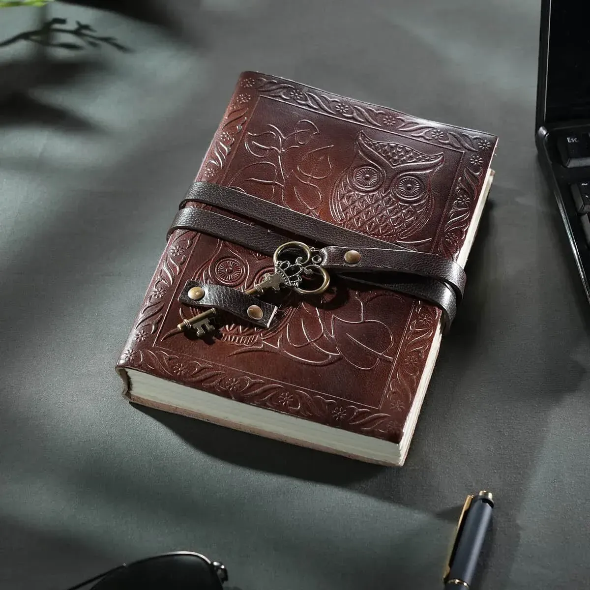 Owl embossed leather bound journal on gray desk. 